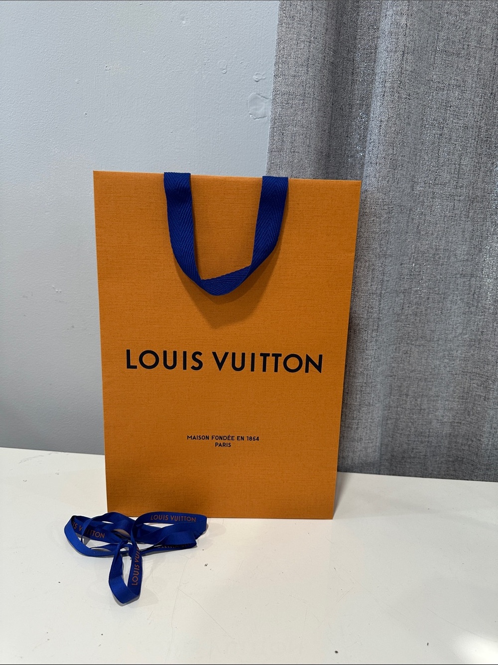 Authentic Louis Vuitton orange empty shopping bag.